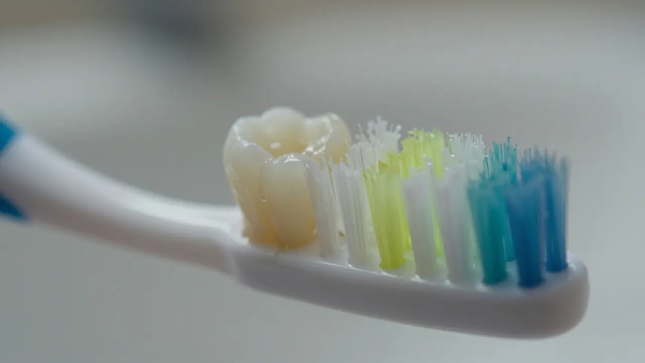 Detailní pohled na zubní kartáček, který nedostává do mezer mezi překrývajícími se zuby.